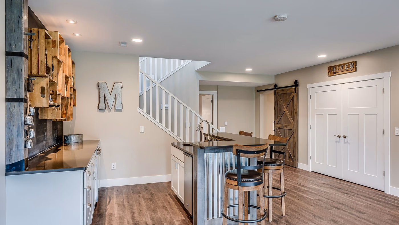 Modern basement bar and entertainment area with custom built-ins by Brewer Construction